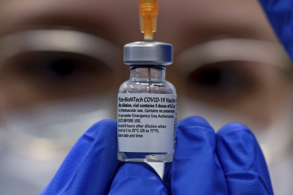 FILE - Pharmacist Lena Springmann prepares a Covid-19 vaccination with Pfizer/Biontech vaccine at a vaccination center in Halle, Germany, Monday, Jan. 11, 2021. The Nobel Prize in Medicine has been awarded to two scientists whose work led to mRNA vaccines against COVID-19. (Hendrik Schmidt/dpa via AP, File)