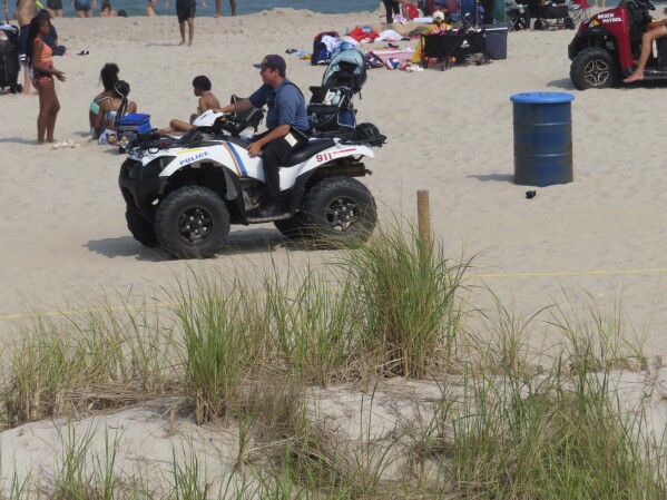 A police officer in a dune vehicle patrols the beach in Seaside Heights, N.J., on Thursday, June 29, 2023. Officials and residents of several New Jersey shore towns say the state’s law decriminalizing marijuana use is having an unintended effect: emboldening large groups of teenagers to run amok on beaches and boardwalks, knowing there is little chance of them getting in trouble for it. (AP Photo/Wayne Parry)