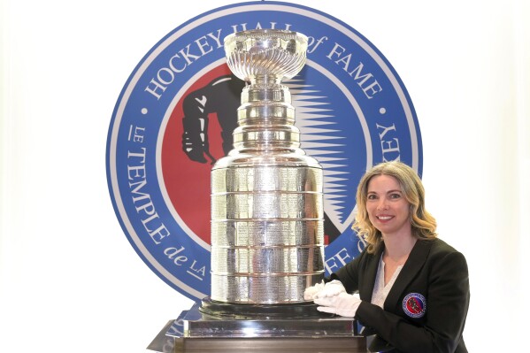 Cup Keeper Miragh Bitove is photographed with the Stanley Cup at the Hockey Hall of Fame in Toronto on Thursday, April 11, 2024. (Chris Young/The Canadian Press via AP)