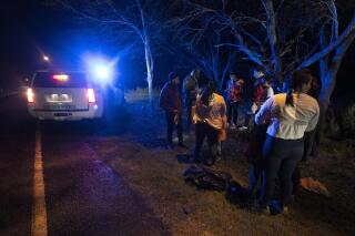 Un agente de inmigración detiene a un grupo de migrantes centroamericanos cuando caminaban en una carretera tras haber cruzado la frontera entre Texas y México, el viernes 12 de mayo de 2023, en Fronton, Texas. (AP Foto/Julio Cortez)