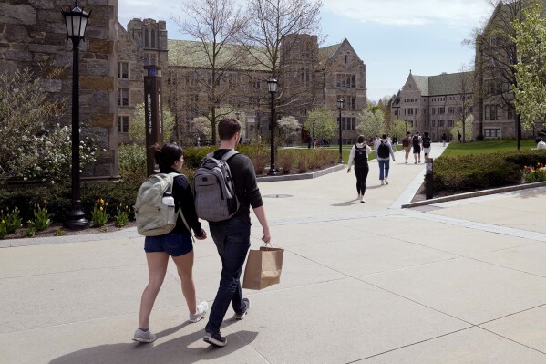 FILE - Students walk on the campus of Boston College, Monday, April 29, 2024, in Boston. Americans are increasingly skeptical about the value and cost of college, with most saying they feel the U.S. higher education system is headed in the “wrong direction,” according to a new poll. (AP Photo/Charles Krupa, File)