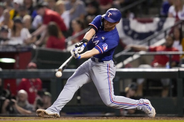 Texas Rangers' Corey Seager hits a single against the Arizona Diamondbacks during the seventh inning in Game 5 of the baseball World Series Wednesday, Nov. 1, 2023, in Phoenix. (AP Photo/Godofredo A. Vásquez)