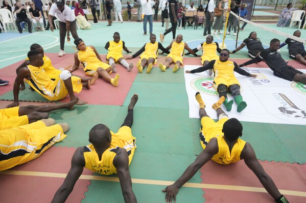 Peacemaker Azuegbulam, 27, Africa's first gold medalist at the Invictus Games, center left, warms up before an exhibition sitting volleyball match in Abuja Nigeria, Saturday, May 11, 2024. He was among the soldiers deployed during Nigeria's grinding counter-offensive against Islamic extremists in the northeastern Borno state in 2020 when an anti-aircraft weapon was fired at them. By the time he regained consciousness, his life was no longer the same, starting with his left leg which was later amputated. (AP Photo/Sunday Alamba)