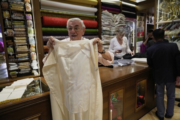 Italian tailor Raniero Mancinelli, who on his own initiative is making outfits for a possible future Pope, shows a pontiff's unfinished garment as he is interviewed by the Associated Press inside his shop in Rome, Wednesday, April 30, 2025. (AP Photo/Gregorio Borgia)