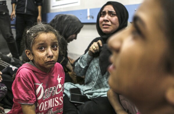 Wounded Palestinians sit in al-Shifa hospital in Gaza City, central Gaza Strip, after arriving from al-Ahli hospital following an explosion there, Tuesday, Oct. 17, 2023. (AP Photo/Abed Khaled)