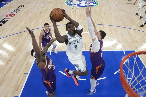 Minnesota Timberwolves guard Anthony Edwards (5) goes up for a shot as Phoenix Suns guard Bradley Beal, left, and center Jusuf Nurkic, right, defend during the second half of Game 2 of an NBA basketball first-round playoff series Tuesday, April 23, 2024, in Minneapolis. (AP Photo/Abbie Parr)