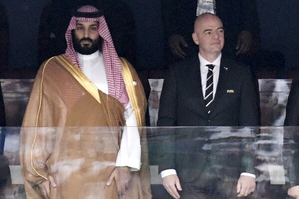 FILE - Saudi Arabia Crown Prince Mohammed bin Salman, left, and FIFA President Gianni Infantino, stand for the anthem prior to the match between Russia and Saudi Arabia which opened the 2018 soccer World Cup at the Luzhniki stadium in Moscow, Russia, on June 14, 2018. A complaint alleging abuses of migrant workers in Saudi Arabia was filed with the UN-backed International Labor Organization on Wednesday, June 5, 2024, as FIFA prepares to confirm the oil-rich kingdom as host of the 2034 World Cup. (Alexei Nikolsky, Sputnik, Kremlin Pool Photo via AP, File)