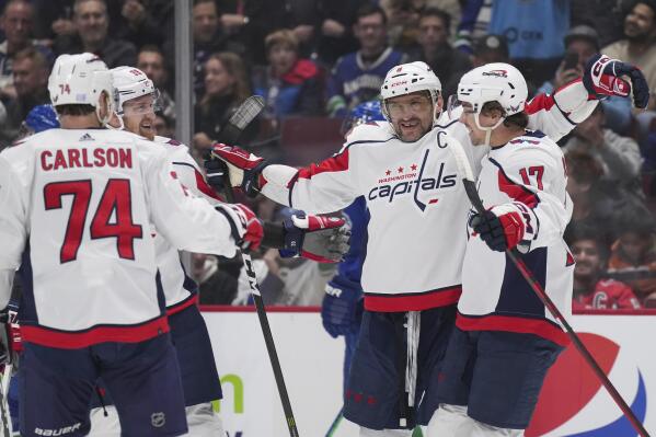 Washington Capitals' Alex Ovechkin (8), Dylan Strome (17), Anthony Mantha (39) and John Carlson (74) celebrate Ovechkin's second goal against the Vancouver Canucks during the first period of an NHL hockey game Tuesday, Nov. 29, 2022, in Vancouver, British Columbia. (Darryl Dyck/The Canadian Press via AP)