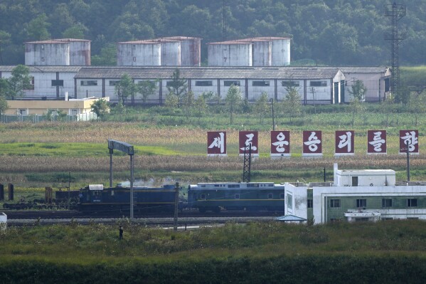 A green train with yellow trimmings, resembling one used by North Korean leader Kim Jong Un on his previous travels, is seen steaming by a slogan which reads "Towards a new victory" on the North Korea border with Russia and China seen from China's Yiyanwang Three Kingdoms viewing platform in Fangchuan in northeastern China's Jilin province on Monday, Sept. 11, 2023. Russia and North Korea confirmed Monday that North Korean leader Kim Jong Un will visit Russia in a highly anticipated meeting with President Vladimir Putin that has sparked Western concerns about a potential arms deal for Moscow's war in Ukraine. (AP Photo/Ng Han Guan)