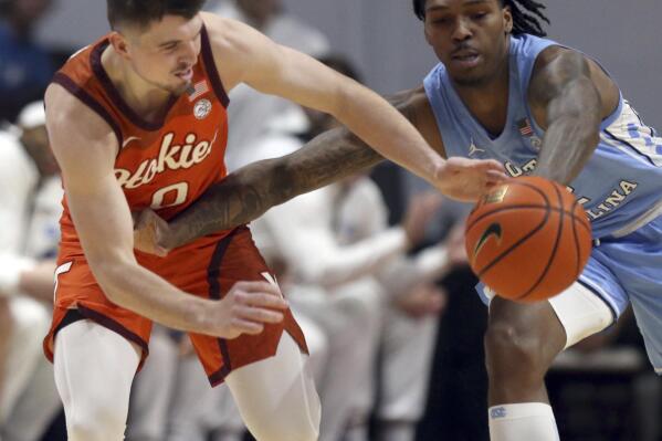 North Carolina's Caleb Love, right, steals a pass intended for Virginia Tech's Hunter Cattoor in the first half of an NCAA college basketball game in Blacksburg Va., Sunday Dec. 4, 2022. (Matt Gentry/The Roanoke Times via AP)