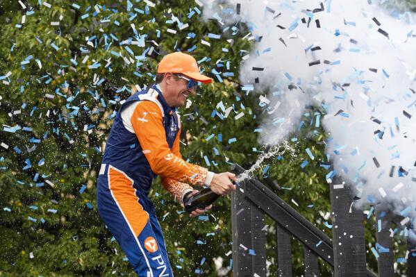 Scott Dixon, of New Zealand, celebrates with champagne in the Winners Circle after winning  an IndyCar auto race in Toronto, Sunday, July 17, 2022. (Mark Blinch/The Canadian Press via AP)