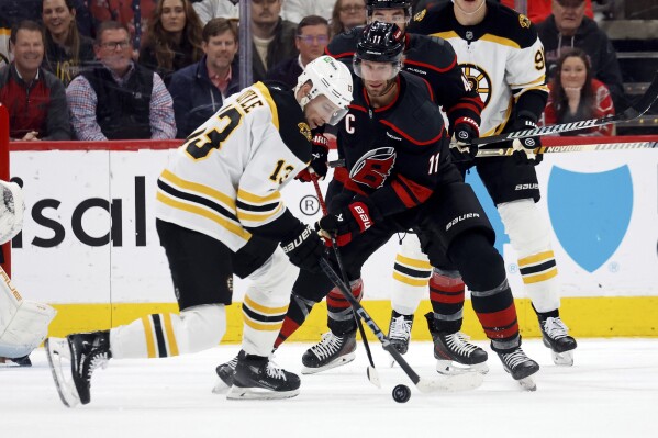 Carolina Hurricanes' Jordan Staal (11) battles for the puck with Boston Bruins' Charlie Coyle (13) during the first period of an NHL hockey game in Raleigh, N.C., Thursday, March 6, 2025. (AP Photo/Karl DeBlaker)