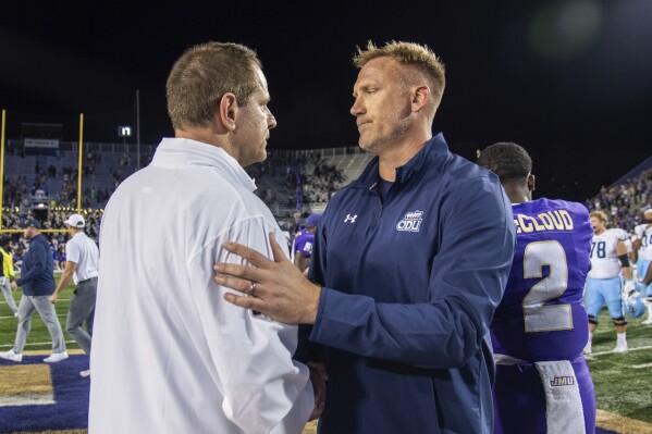 James Madison coach Curt Cignetti, left, meets with Old Dominion coach Ricky Rahne after an NCAA college football game Saturday, Oct. 28, 2023, in Harrisonburg, Va. (AP Photo/Mike Caudill)