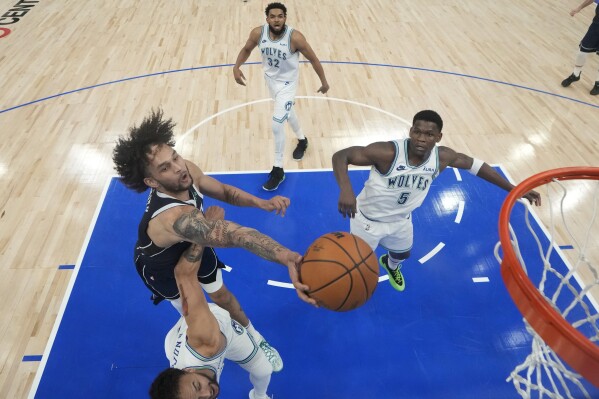 Dallas Mavericks center Dereck Lively II, left, reaches for a rebound between Minnesota Timberwolves forward Kyle Anderson, bottom, and guard Anthony Edwards (5) during the first half of Game 1 of the NBA basketball Western Conference finals, Wednesday, May 22, 2024, in Minneapolis. (AP Photo/Abbie Parr)