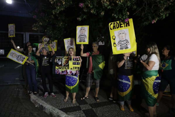 
              Demonstrators protest outside the federal police headquarter as they wait for a convoy bringing Brazilian former President Luiz Inacio Lula da Silva in Sao Paulo, Brazil, Saturday, April 7, 2018. Da Silva begun serving a sentence of 12 years and one month for a corruption conviction. (AP Photo/Andre Penner) Demonstrators protest outside the federal police headquarters in Sao Paulo, Brazil, Saturday, April 7, 2018 as they wait for a convoy bringing former President Luiz Inacio Lula da Silva. Da Silva began serving a sentence of 12 years and one month for a corruption conviction. (AP Photo/Andre Penner)
            