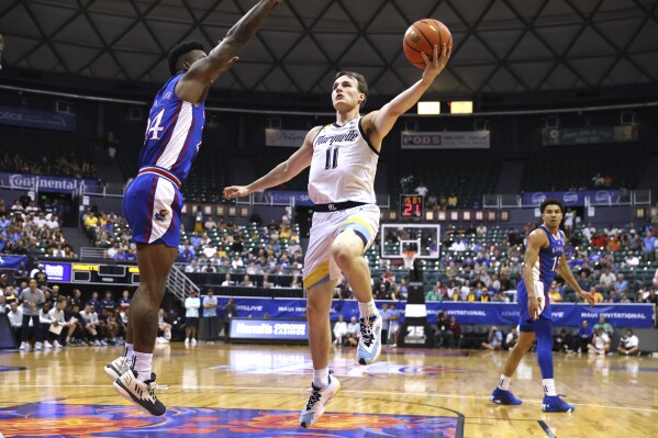 Marquette guard Tyler Kolek (11) shoots against Kansas forward K.J. Adams Jr. (24) during the first half of an NCAA college basketball game Tuesday, Nov. 21, 2023, in Honolulu. (AP Photo/Marco Garcia)