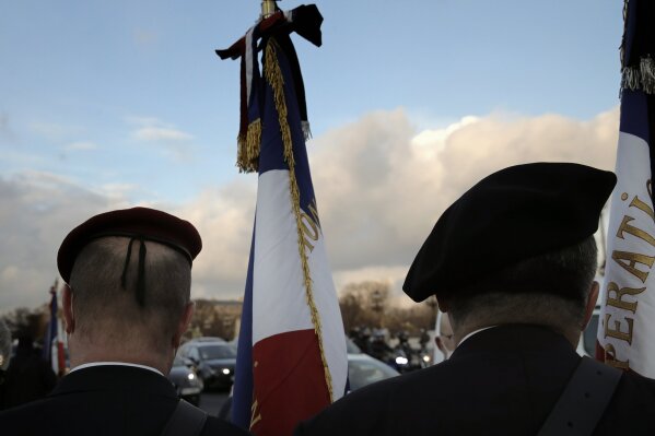 French veterans stand before a ceremony held on the Alexandre III bridge in central Paris, Thursday Jan.7, 2021 to pay homage to two soldiers killed in Mali by an improvised explosive device that hit their armored vehicle on Saturday. Three other French soldiers died just five days earlier in similar circumstances. (AP Photo/Christophe Ena)
