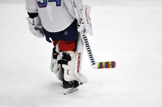 FILE - Florida Panthers goaltender Alex Lyon (34) warms up while celebrating Pride Night with a colorful hockey stick before playing the Toronto Maple Leafs, Thursday, March 23, 2023, in Sunrise, Fla. The NHL sent a memo to teams last week clarifying what players could and could not do as part of theme nights this season, including Pride celebrations that had become a hot-button issue in hockey. Deputy Commissioner Bill Daly confirmed to The Associated Press on Tuesday, Oct. 10, that the league sent the updated memo to teams.(AP Photo/Michael Laughlin, File)