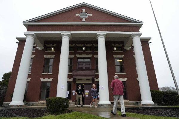 Voters enter and exit a polling facility at the Seale Courthouse in Russell County during a primary election, Tuesday, March 5, 2024, in Seale, Ala. About 6,000 voters in a new congressional district, that includes Russell County, formed to boost Black representation, received postcards with incorrect voting information ahead of Tuesday’s primary election. (AP Photo/Mike Stewart)