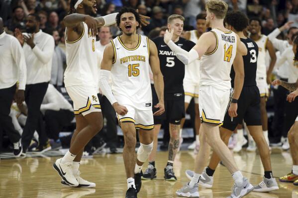 Providence's Nate Watson (0), Justin Minaya (15), and Noah Horchler (14) celebrate a triple overtime win following an NCAA college basketball game against Xavier Wednesday, Feb. 23, 2022, in Providence, R.I. (AP Photo/Stew Milne)