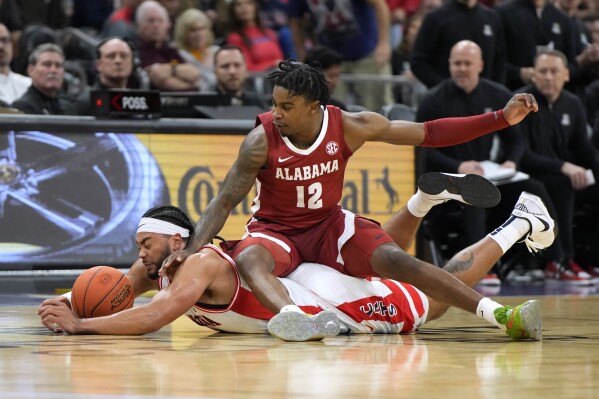 Arizona guard Kylan Boswell and Alabama guard Latrell Wrightsell Jr. (12) dive for the ball during the first half of an NCAA college basketball game Wednesday, Dec. 20, 2023, in Phoenix. (AP Photo/Rick Scuteri)