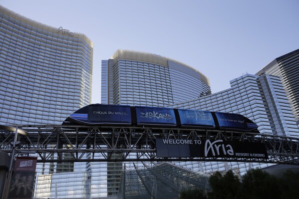 FILE - A tram travels by the front of the Aria Resort & Casino, Thursday, Aug. 14, 2014, in Las Vegas. A former operations manager at the Las Vegas Strip resort is facing 15 felony charges alleging he siphoned more than $773,000 in hotel refunds into a personal account that he used for luxury shopping, expensive dinners, spa treatments and private jet flights. Brandon Rashaad Johnson, 38, of Las Vegas remained jailed Friday, Sept. 8, 2023, following his arrest Sept. 1. (AP Photo/John Locher, File)