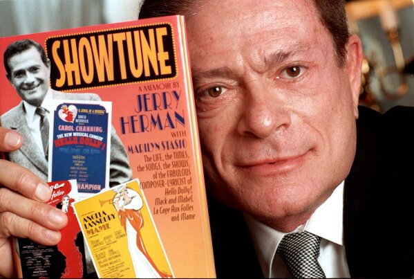 FILE - In this Nov. 19, 1996, file photo, composer Jerry Herman displays his book "Showtune," in New York. Herman, the Tony Award-winning composer behind "Hello, Dolly!" and "La Cage aux Folles," has died at age 88. (AP Photo/Jim Cooper, File)