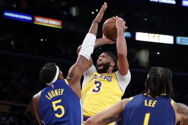 Los Angeles Lakers forward Anthony Davis (3) shoots against Golden State Warriors center Kevon Looney (5) during the first half of an NBA basketball game in Los Angeles, Tuesday, Oct. 19, 2021. (AP Photo/Ringo H.W. Chiu)