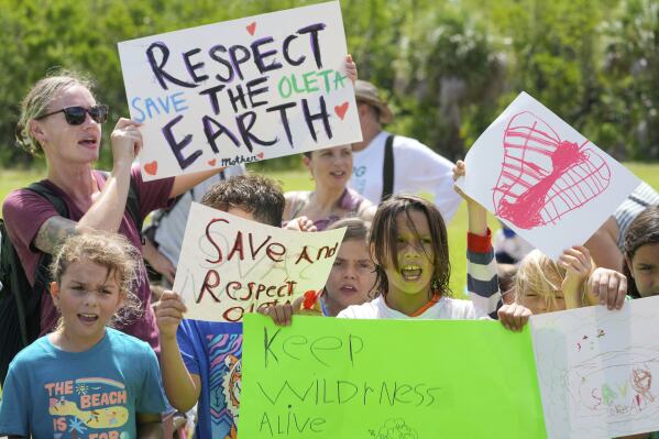 Protesters chant against Gov. Ron DeSantis' plan to develop state parks with business ventures such as golf courses, pickleball courts and large hotels, during a demonstration at Oleta River State Park, Tuesday, Aug. 27, 2024, in North Miami Beach, Fla. (AP Photo/Wilfredo Lee, File)