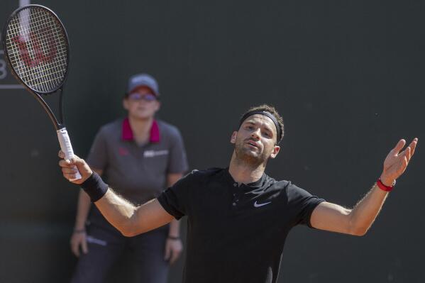 Grigor Dimitrov of Bulgaria reacts after winning a game against Taylor Fritz of the United States during their semifinal match at the ATP 250 Geneva Open tennis tournament in Geneva, Switzerland, Friday, May 26, 2023. (Martial Trezzini/Keystone via AP)