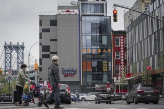 A six story glass facade building, center, alleged to be the site of a foreign police outpost for China in New York's Chinatown, Monday, April 17, 2023. (AP Photo/Bebeto Matthews, File)