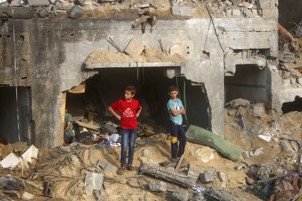 Palestinians inspect the damage of a destroyed house that was hit by an Israeli airstrike in town of Khan Younis, southern Gaza Strip, Tuesday, Oct. 24, 2023. (AP Photo/Mohammed Dahman)
