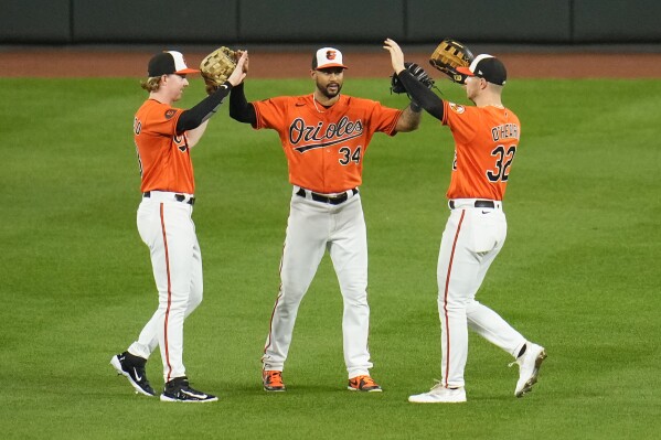 Baltimore Orioles outfielders Heston Kjerstad, left, Aaron Hicks (34) and Ryan O'Hearn (32) react after a baseball game against the Boston Red Sox, Saturday, Sept. 30, 2023, in Baltimore. The Orioles won 5-2. (AP Photo/Julio Cortez)