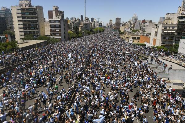 Argentine soccer fans crowd a highway for a homecoming parade for the Argentine soccer team that won the World Cup tournament in Buenos Aires, Argentina, Tuesday, Dec. 20, 2022. (AP Photo/Gustavo Garello)