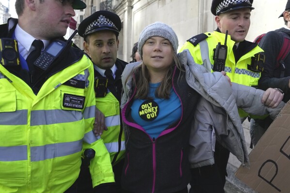 Environmental activist Greta Thunberg is taken away by police officers during the Oily Money Out protest outside the Intercontinental Hostel, in London, Tuesday, Oct. 17, 2023. (AP Photo/Kin Cheung)
