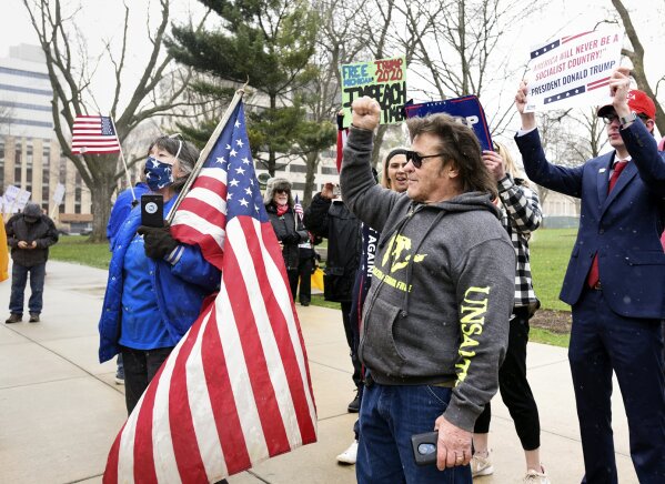 Rallygoers protest against Michigan Gov. Gretchen Whitmer's stay-at-home order at the state Capitol on Wednesday, April 15, 2020, in downtown Lansing, Mich. Hundreds of flag-waving, honking protesters drove past the Michigan Capitol to show their displeasure with Whitmer’s orders to keep people at home and businesses locked during the coronavirus outbreak. (Matthew Dae Smith/Lansing State Journal via AP)