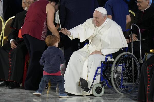 Pope Francis reaches out to a young boy as he attends the Festival of Families in the Paul VI Hall at the Vatican, on the first day of the World Meeting of Families, Wednesday, June 22, 2022. (AP Photo/Andrew Medichini)