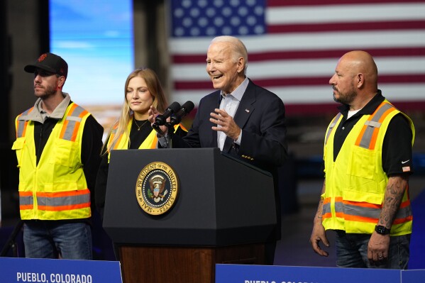 President Joe Biden speaks at CS Wind, Wednesday, Nov. 29, 2023, in Pueblo, Colo., as workers stand on the stage with him. (AP Photo/Jack Dempsey)