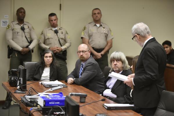 FILE - Louise Anna Turpin, far left, with attorney Jeff Moore, second from left, and her husband David Allen Turpin, listen to attorney, David Macher, as they appear in court for their arraignment in Riverside, Calif., on Jan. 18, 2018. Several adult children among the 13 siblings freed in 2018 from virtual imprisonment in their abusive parents’ Southern California home found themselves a year later feeling pressured by the county’s guardian to move to an apartment in disrepair in a crime-ridden area, court documents showed. (Frederic J. Brown/Pool Photo via AP)