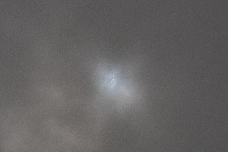 FILE - A total solar eclipse is barely visible through the clouds in Carahue, La Araucania, Chile Monday, Dec. 14, 2020. The total eclipse was visible from Chile and the northern Patagonia region of Argentina, and as a partial solar eclipse in Bolivia, Brazil, Ecuador, Paraguay, Peru and Uruguay. (AP Photo/Esteban Felix, File)