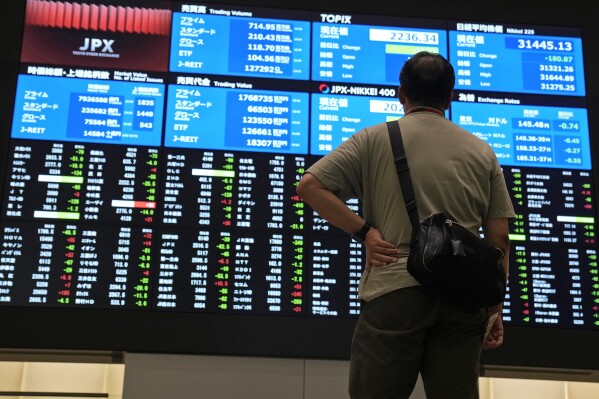 A visitor looks at an electronic stock board at Tokyo Stock Exchange Friday, Aug. 18, 2023 in Tokyo, Japan. Asian stock markets were mostly lower Thursday, Aug. 31, after Japanese factory activity and Chinese service industry growth weakened.(AP Photo/Shuji Kajiyama)