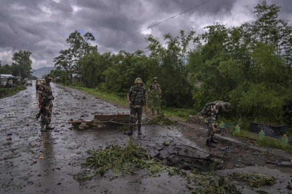Indian paramilitary soldiers inspect the site of a car bomb explosion in Kwakta, some 50 kilometers from Imphal, capital of the northeastern Indian state of Manipur, Thursday, June 22, 2023. Manipur is caught in a deadly conflict between two ethnic communities that have armed themselves and launched brutal attacks against one another. The clashes, which have left at least 120 dead by the authorities' conservative estimates, persist despite the army’s presence. (AP Photo/Altaf Qadri)