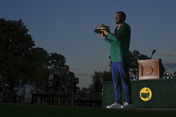 Scottie Scheffler holds the trophy after winning the Masters golf tournament at Augusta National Golf Club Sunday, April 14, 2024, in Augusta, Ga. (AP Photo/Matt Slocum)