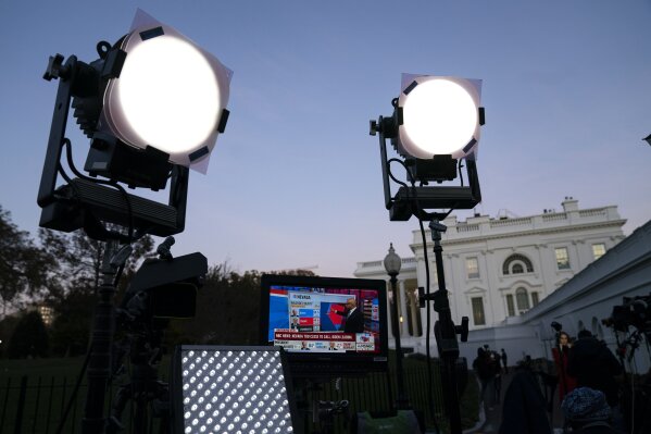 FILE - In this Nov. 6, 2020, file photo, media organizations set up outside the White House in Washington. The Associated Press and the major TV networks have long played a major role in announcing the victor in elections based on their own data. There is no national elections commission to tell the world who wins on election day, unlike in many other countries. Instead, the news media has historically stepped into this role — a tradition that evolved from the simple need to report the news. (AP Photo/Evan Vucci, File)