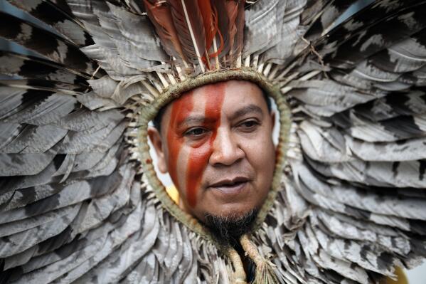 An indigenous representative from Brazil protests outside Paris courthouse, in Paris, Thursday, June 9, 2022. Environmental groups and representatives of Brazil's Indigenous community are protesting Thursday outside the main Paris courthouse, urging a quick trial for a French supermarket chain accused of selling beef linked to deforestation and land grabs in the Amazon rainforest. (AP Photo/Thibault Camus)