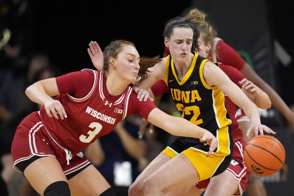 Wisconsin guard Brooke Schramek (3) steals the ball from Iowa guard Caitlin Clark (22) during the first half of an NCAA college basketball game, Tuesday, Jan. 16, 2024, in Iowa City, Iowa. (AP Photo/Charlie Neibergall)