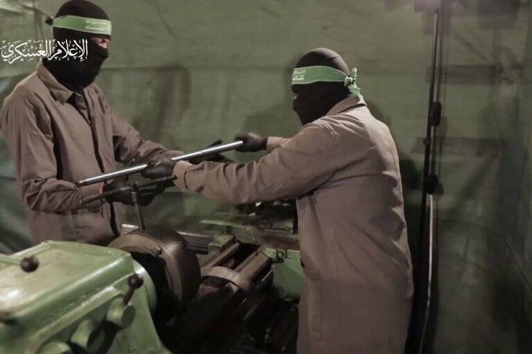 This image from video posted by Hamas on Dec. 20, 2023, purports to show Hamas militants using machining equipment to make their own domestic copies of the AM-50 Sayyad, an Iranian-made a sniper rifle that fires a .50- caliber round powerful enough to punch through up to an inch of steel. Experts interviewed by The Associated Press said it would be nearly impossible for Hamas to manufacture a safe and accurate sniper rifle using the rudimentary equipment shown in the video. Watermark at upper left reads “military media.” (Hamas via AP)