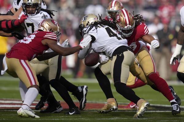 New Orleans Saints running back Alvin Kamara, middle, fumbles the ball between San Francisco 49ers cornerback Deommodore Lenoir, left, and linebacker Fred Warner during the first half of an NFL football game in Santa Clara, Calif., Sunday, Nov. 27, 2022. The 49ers recovered the ball. (AP Photo/Godofredo A. Vásquez)
