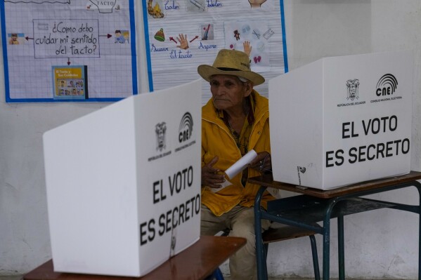 A voter holds his ballot during a runoff presidential election in Olon, Ecuador, Sunday, Oct. 15, 2023. (AP Photo/Martin Mejia)