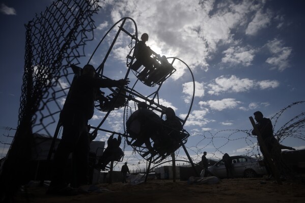 Palestinian kids displaced by the Israeli ground offensive on the Gaza Strip play at a makeshift tent camp in Rafah, Gaza Strip, Sunday, Feb. 18, 2024. (AP Photo/Mohammed Dahman)